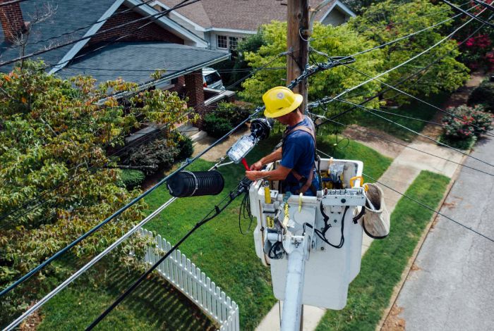 An electric worker checks and repairs electric wire on pole